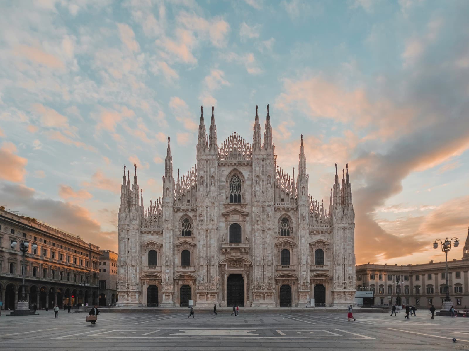 Il Duomo di Milano visto da piazza del Duomo al tramonto, con il cielo rosa e azzurro