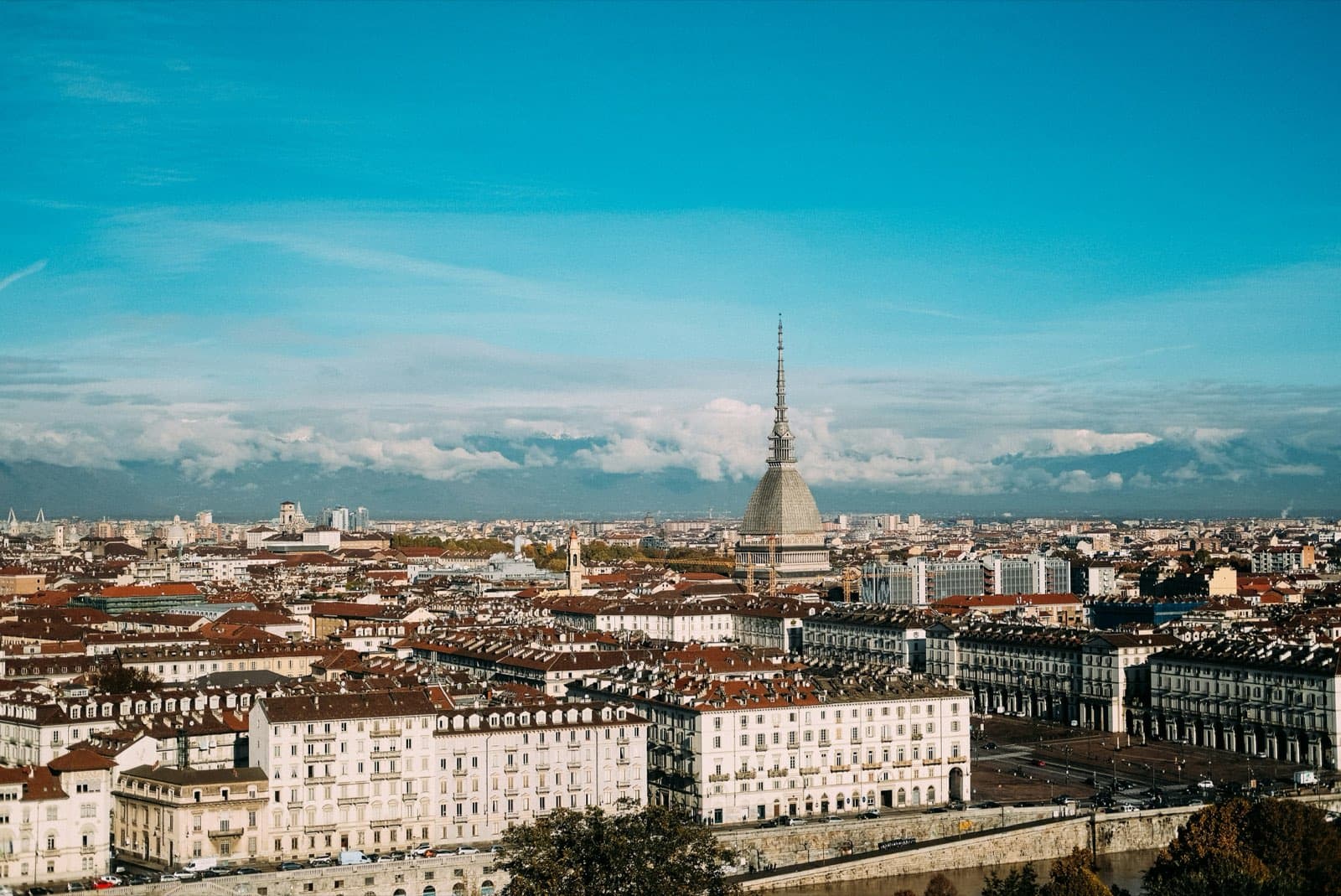 Panorama di Torino dall'alto con la Mole Antonelliana, i tetti del centro e le Alpi tra le nuvole