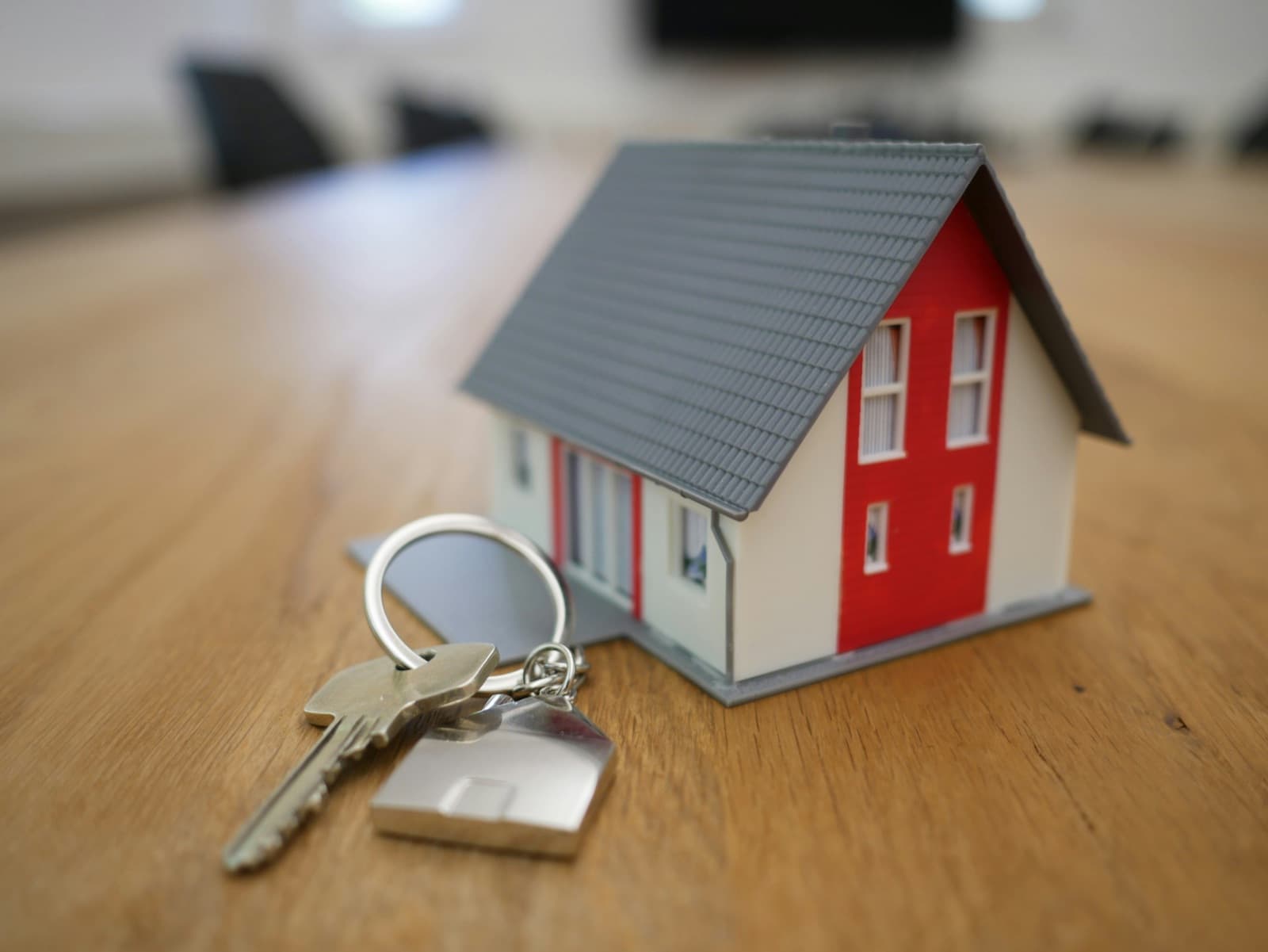 Modellino di casa con un mazzo di chiavi su un tavolo di legno